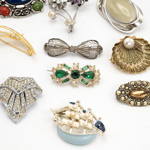 12 - Collection of vintage costume jewellery brooches, including some silver examples.