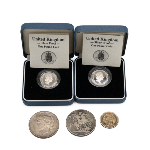 105 - Two silver £1 coins, along with an 1822 silver crown, an American half dollar and one other coin.