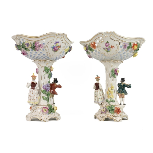 145 - Two late 19th century Dresden pierced comports, each column flanked with figures of a gentleman play... 