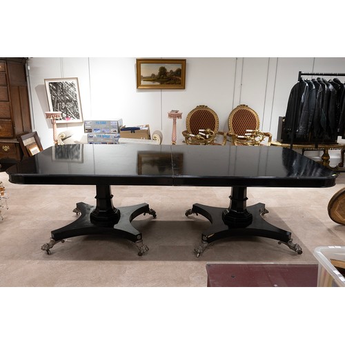 515 - Regency style ebonised pedestal dining table, the top with rounded corners raised on two octagonal s... 