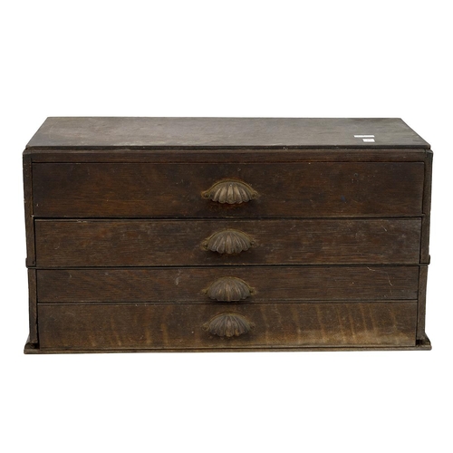 519 - A 1940's oak four drawer collectors cabinet with brass shell handles, the upper drawer sectioned wit... 