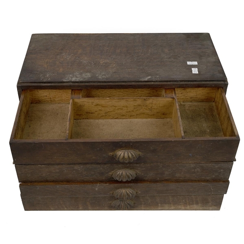 519 - A 1940's oak four drawer collectors cabinet with brass shell handles, the upper drawer sectioned wit... 