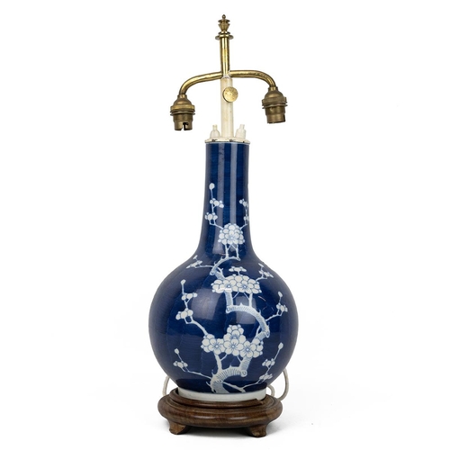 237 - A Chinese blue and white vase, decorated with white flowering plum tree on deep blue ground, on a wo... 