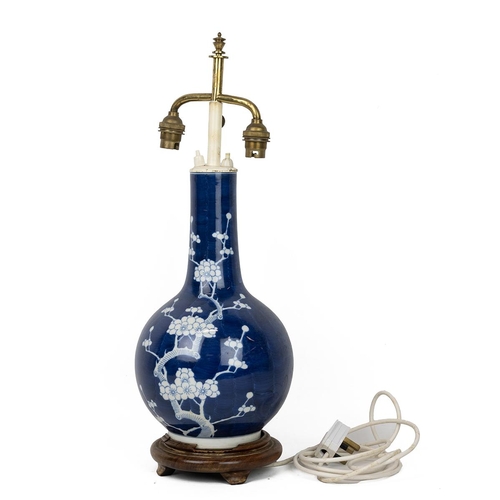 237 - A Chinese blue and white vase, decorated with white flowering plum tree on deep blue ground, on a wo... 