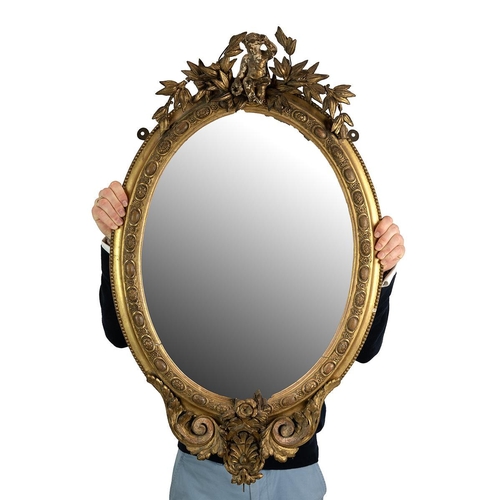 547 - 19th-century gilt framed oval mirror the top adorned with a cherub among wreaths, egg and rose motif... 