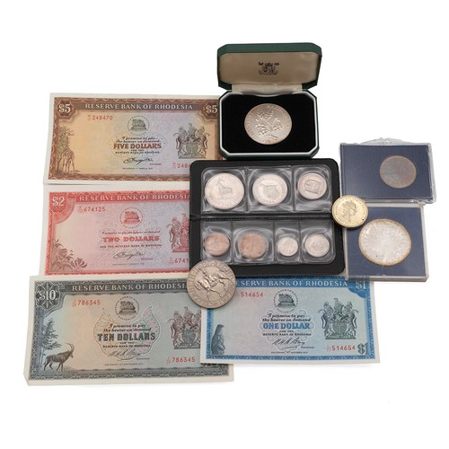 38 - A collection of mixed coins to include Maria Theresa Thaler, National Trust coins, Rhodesian notes a... 