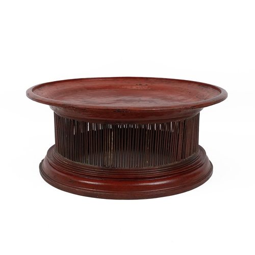 208 - Burmese red lacquered tray table with circular top, raised on a spindle body to a stepped circular b... 