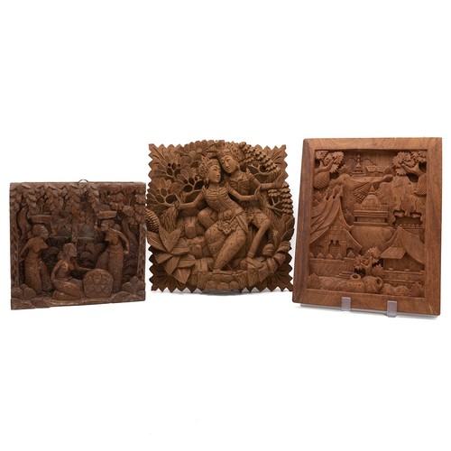 211 - Three Asian wooden carved panels from Bali, Laos and Thailand. One panel depicts a landscape with bu... 