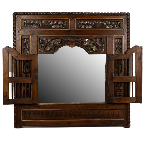 213 - Carved Indonesian teak mirror, the frame comprising fretwork panels with polychrome detailing, centr... 