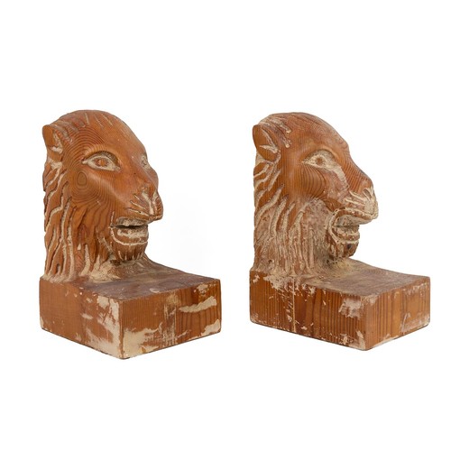 197 - A pair of bookends in form of lion heads. Carved pine. Each W 14cm, D 12cm, H 22cm.