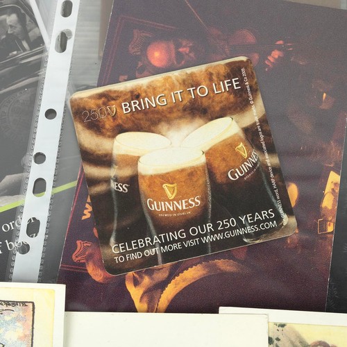 286 - A collection of Guinness related items, including advertising postcards and beer mats, contained in ... 