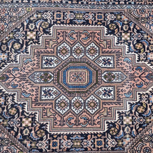 375 - Three rugs to include a Persian hand-knotted runner with fringed ends (L 330CM x W 76CM); a Machine ... 