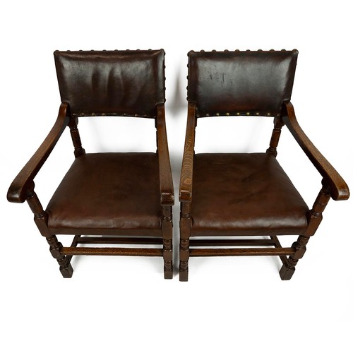 421 - Pair of Oak and leather armchairs, c1900. Turned supports with shaped arms. Leather to seat and back... 