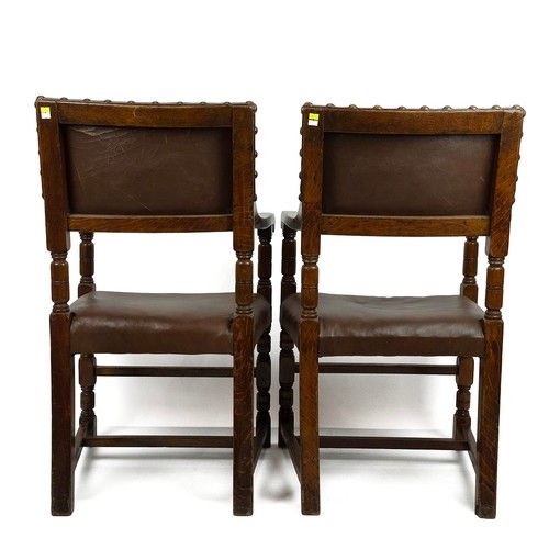 421 - Pair of Oak and leather armchairs, c1900. Turned supports with shaped arms. Leather to seat and back... 