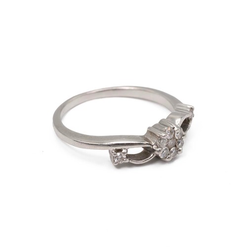 27 - A 950 platinum and diamond set ring, the central flower shaped panel set with brilliant cut diamonds... 