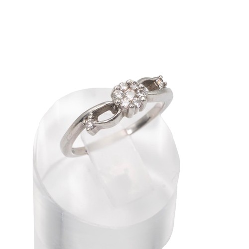 27 - A 950 platinum and diamond set ring, the central flower shaped panel set with brilliant cut diamonds... 