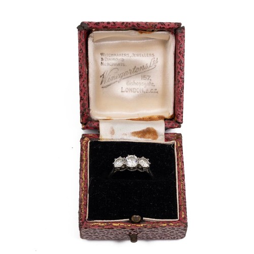 91 - A three-stone diamond ring, set in a raised platinum mount and claw setting, the central diamond app... 