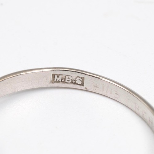 91 - A three-stone diamond ring, set in a raised platinum mount and claw setting, the central diamond app... 