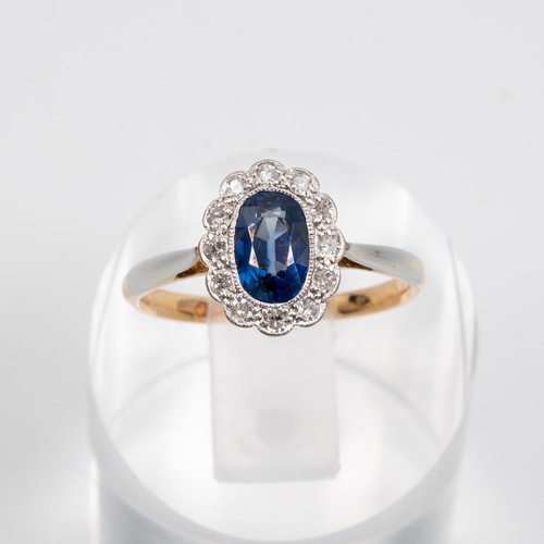 124 - An 18ct gold sapphire and diamond cluster ring, set with a border of 12 brilliant cut diamonds, the ... 