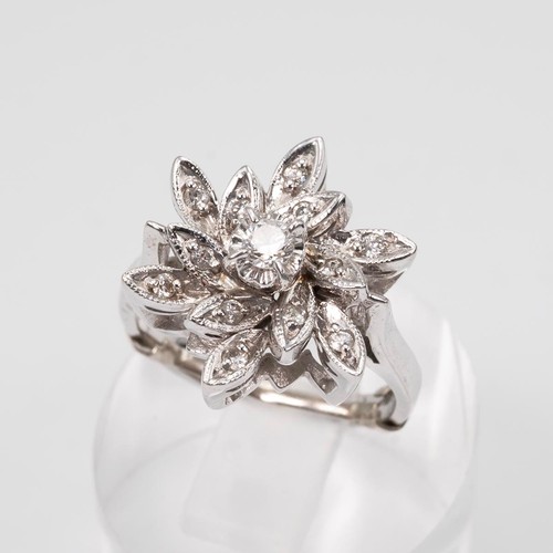 131 - A 14ct white gold and diamond cluster ring in an open setting, in the form of a flower head, the cen... 