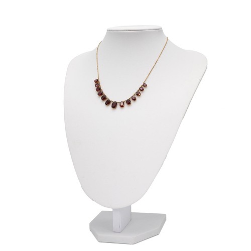 166 - A garnet set necklace the central stone flanked by twelve graduating garnets, wish 'S' shaped clasp,... 