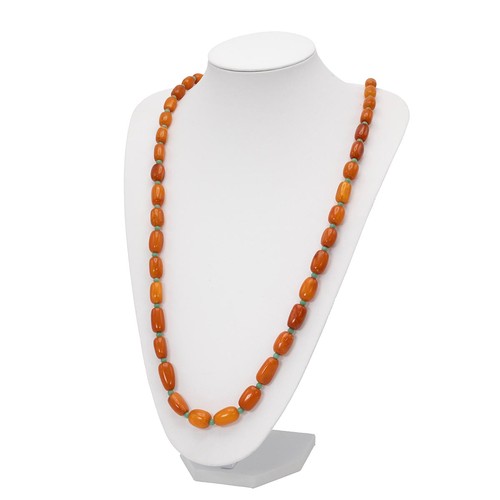 170 - A 20th-century butterscotch amber necklace, set with 48 shaped beads of varying sizes, 86cm long, 55... 