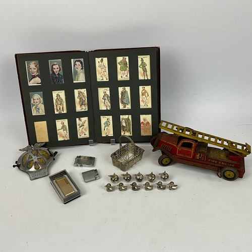 282 - A collection of items to include an AA badge, various lighters, a tin-plated winding clockwork fire ... 