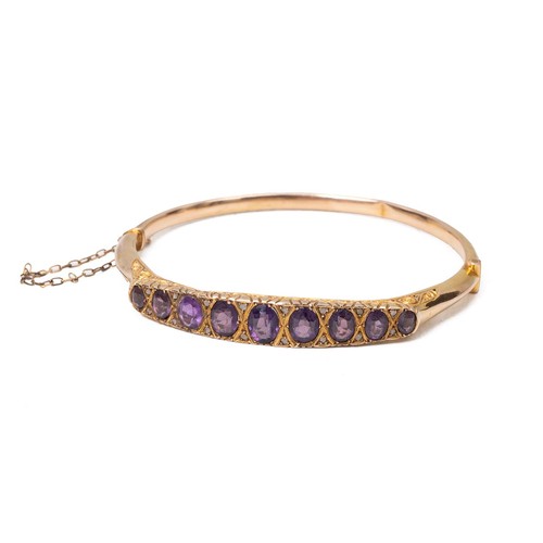 158 - 9ct gold hallmarked bangle, set with nine graduating amethysts flanked by six diamonds set in a rais... 