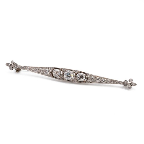 163 - 18ct white gold (tested) with 9ct white gold clip (tested) diamond encrusted bar brooch, the central... 