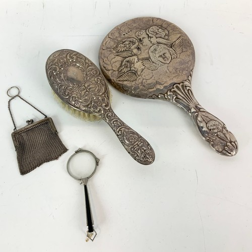 414 - A silver vanity mirror decorated with winged Cherubs hallmarked Birmingham 1905, a silver hair brush... 