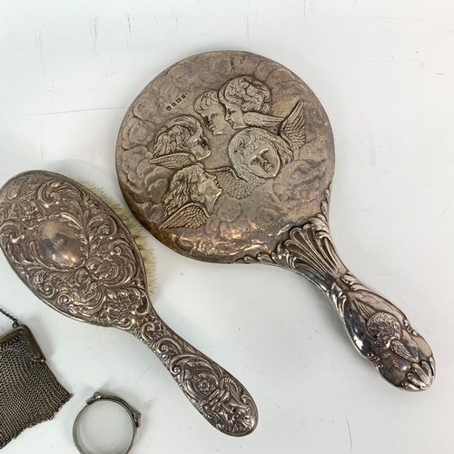 414 - A silver vanity mirror decorated with winged Cherubs hallmarked Birmingham 1905, a silver hair brush... 