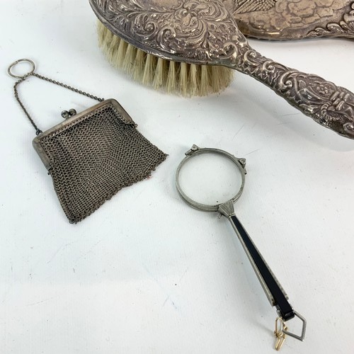 414 - A silver vanity mirror decorated with winged Cherubs hallmarked Birmingham 1905, a silver hair brush... 