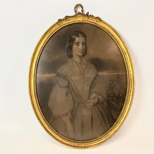 700 - A 19th century charcoal drawing of a lady, in oval plaster and gilt frame, with ribbon finial, unsig... 