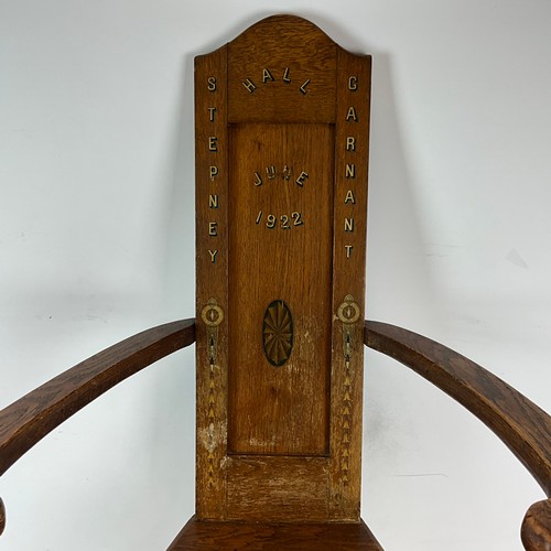900 - A 1922 Eisteddfod chair with fruitwood inlay to legs and back, bowed arm rests with gilt writing dat... 