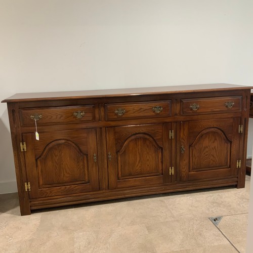 908 - Batheaston oak sideboard, with finely grained top above three drawers with brass drop handles, above... 