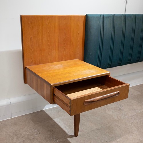 917 - A G-plan teak headboard with padded irredecent fabric with attached single drawer bedside cabinets, ... 