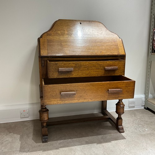 49 - An Art Deco oak bureau, of shaped form, the fall front drawer revealing fitted compartments, with tw... 