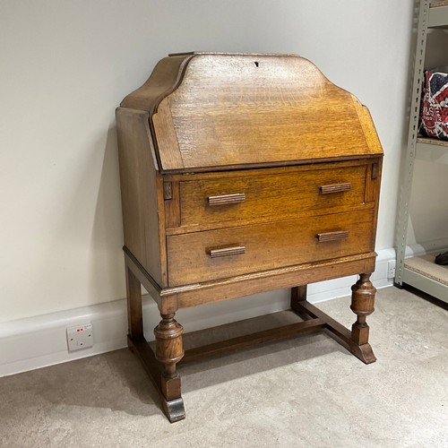 49 - An Art Deco oak bureau, of shaped form, the fall front drawer revealing fitted compartments, with tw... 