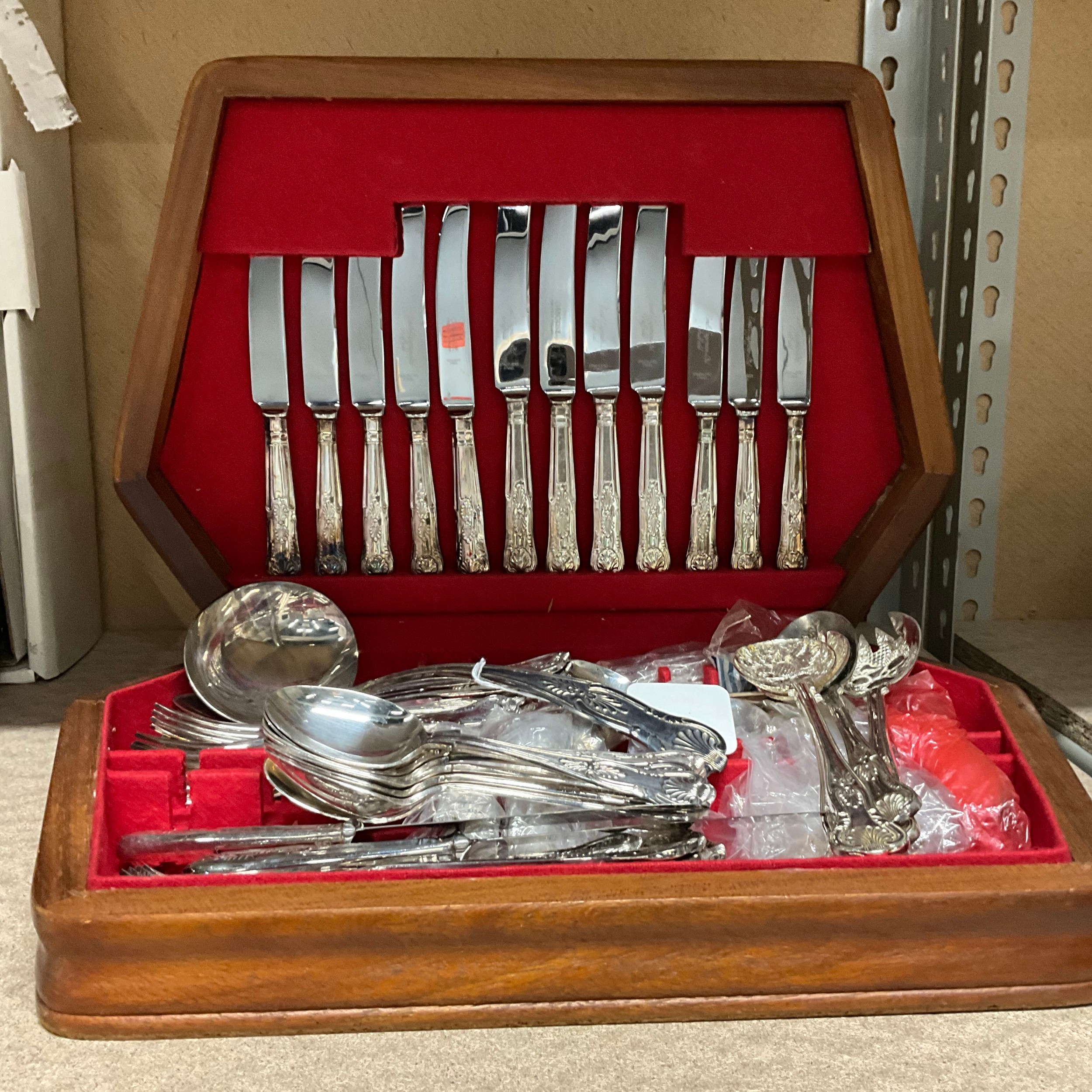 A cased six setting canteen of cutlery and a ladle.