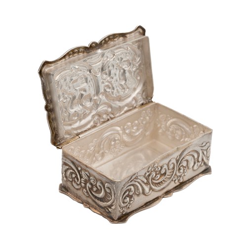 514 - A silver pill box decorated with acanthus flower decorations with two cherubs embossed to lid, hallm... 