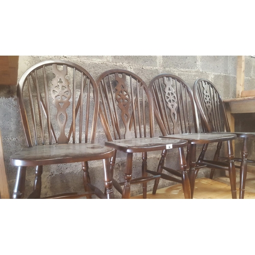 10 - A set of four stained Beech wheel back Dining Chairs.