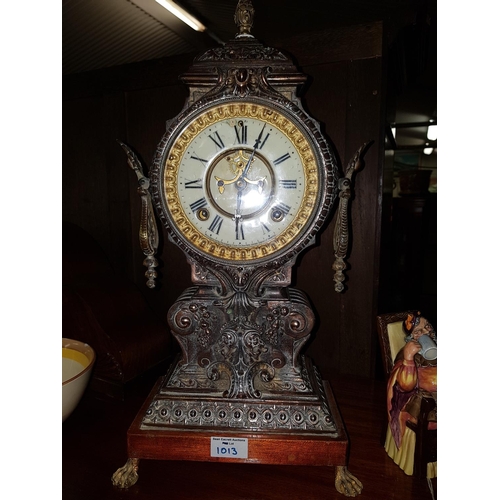 1013 - An ornate cast Metal Mantel Clock, the off white dial inscribed Ansonia Clock Company, height 45 cm.