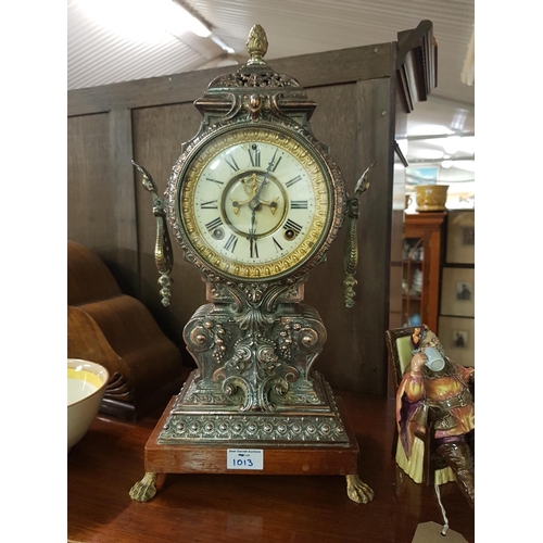 1013 - An ornate cast Metal Mantel Clock, the off white dial inscribed Ansonia Clock Company, height 45 cm.