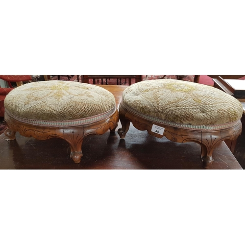 35 - A pair of 19th Century Oval Walnut Showframe Stools with tapestry upholstery.