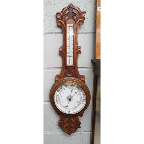 621 - A late 19th early 20th Century carved Oak Aneroid Barometer.