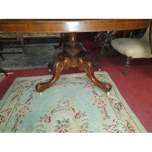 273 - A fantastic Victorian Walnut Inlaid oval Supper Table with splayed carved pod.c1860. 145 x 117 cms.