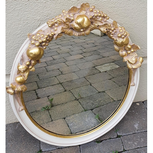 345 - A good oval Gilt and Painted Mirror with bunches of grapes top. 57 x 73 cms approx.