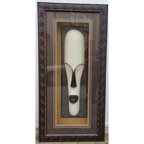 349 - A very large African head in relief in a fully lit Frame. 77 x 160 cms approx.