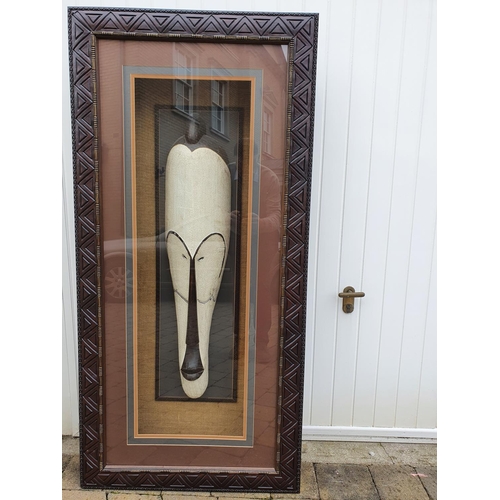 350 - A very large African head in relief in a fully lit Frame. 77 x 160 cms approx.