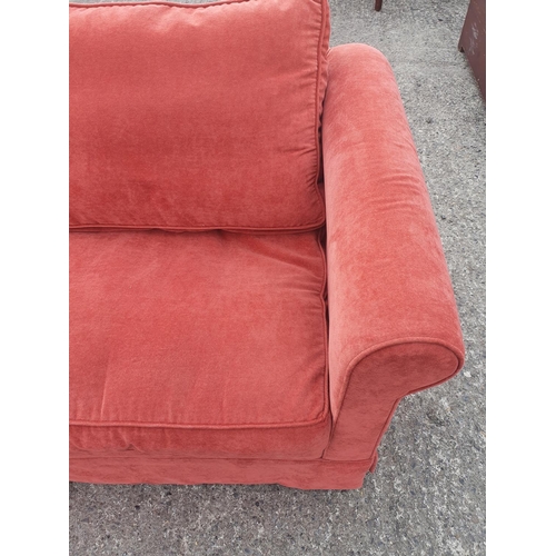 671 - A very clean Pink/Salmon two seater Couch. 175w x 87 deep cms. 